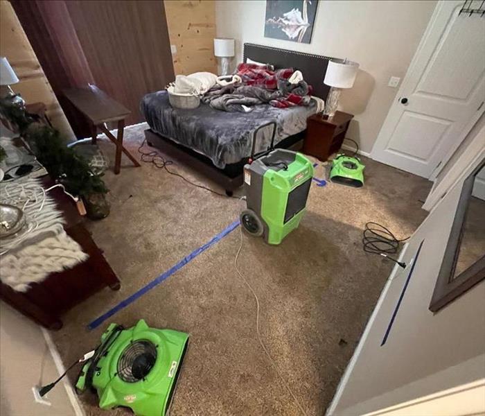 Bedroom with green equipment on floor.