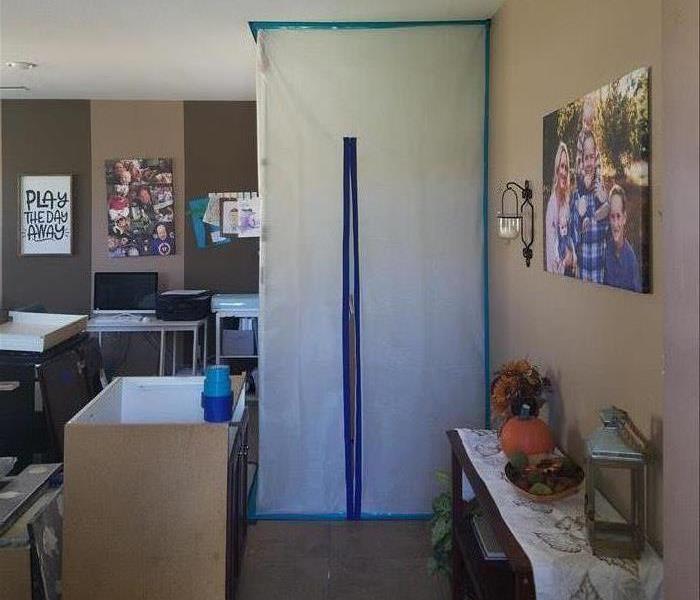 a plastic tent with blue tape in a room