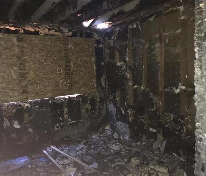 Inside of a empty home burned, windows are boarded up
